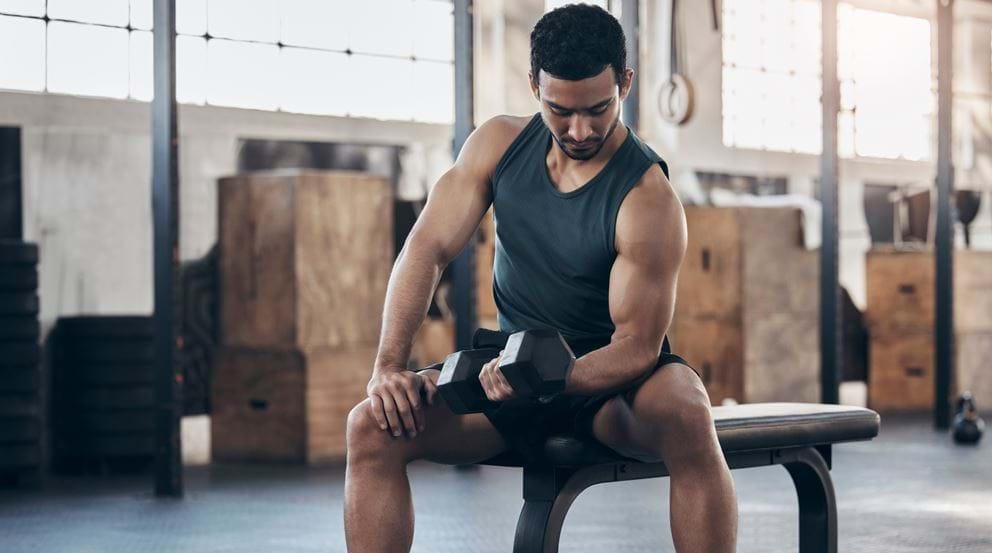 Man performing dumbbell curls at the gym