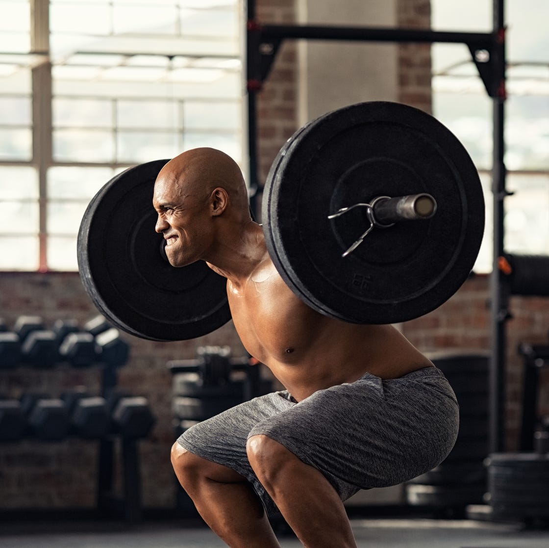 Man performing barbell squat for strength